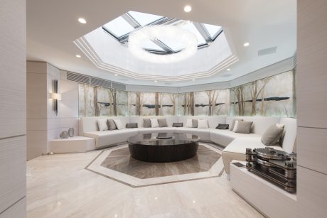 Luxurious circular living room with a grand overhead skylight and ornate decor.