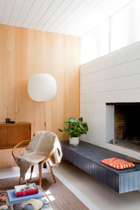 Cozy, inviting living space with wood paneling, fireplace, and modern furnishings.
