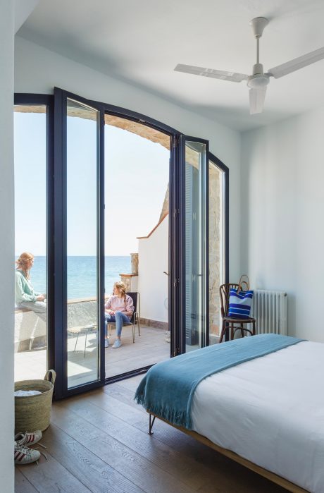 Spacious bedroom with large glass sliding doors overlooking the sea.