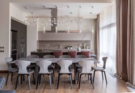 Spacious, modern dining room with sleek furniture, statement lighting, and textured walls.