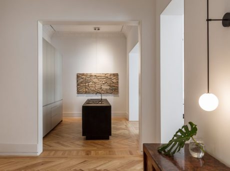 Elegant hallway with recessed lighting, wood-paneled entryway, and modern decor.