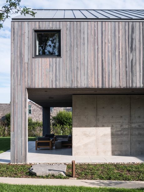 Modernist exterior with concrete, wood, and a recessed covered patio.