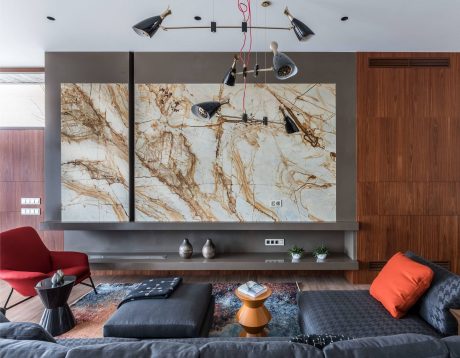 Sleek modern living room with striking marble accent wall and geometric lighting.