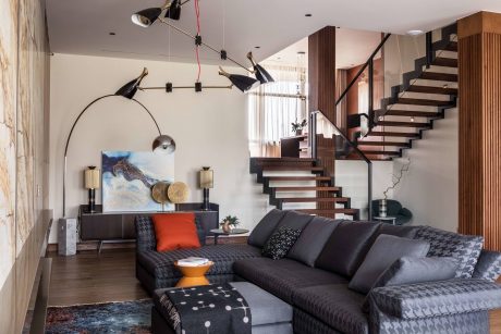 Spacious modern interior with sleek stairs, sectional sofa, and decorative accents.