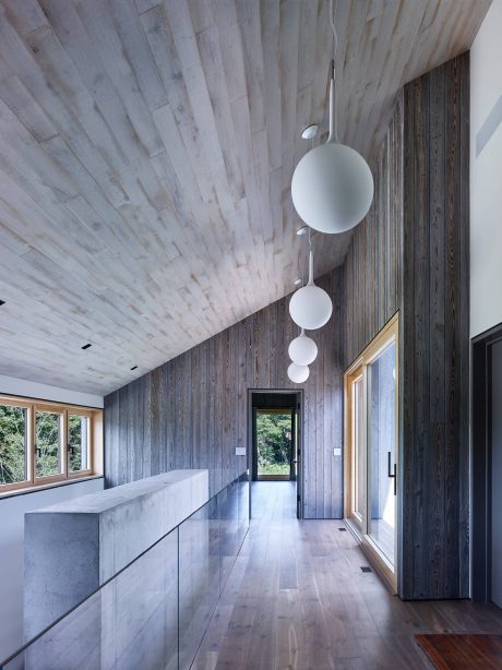 Sleek, modern interior design with wooden walls, marble counter, and pendant lighting.