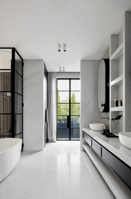 Sleek, minimalist bathroom with floor-to-ceiling marble, modern fixtures, and large window.