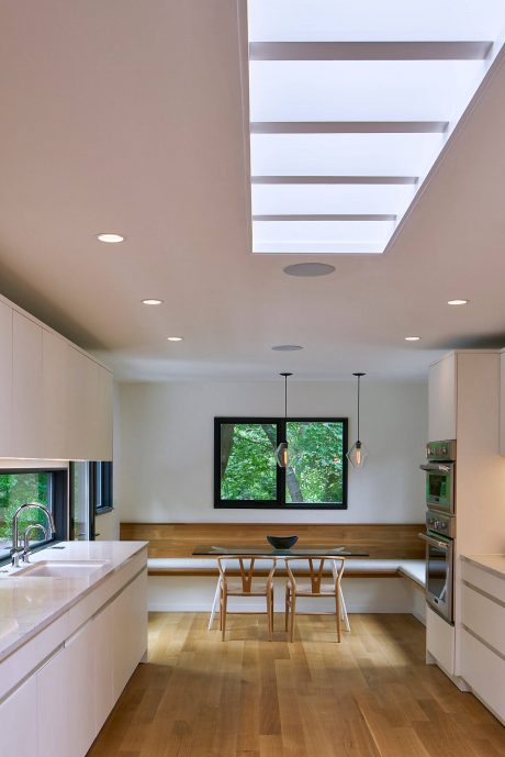 Modern kitchen with clean lines, wood accents, and strategic lighting features.