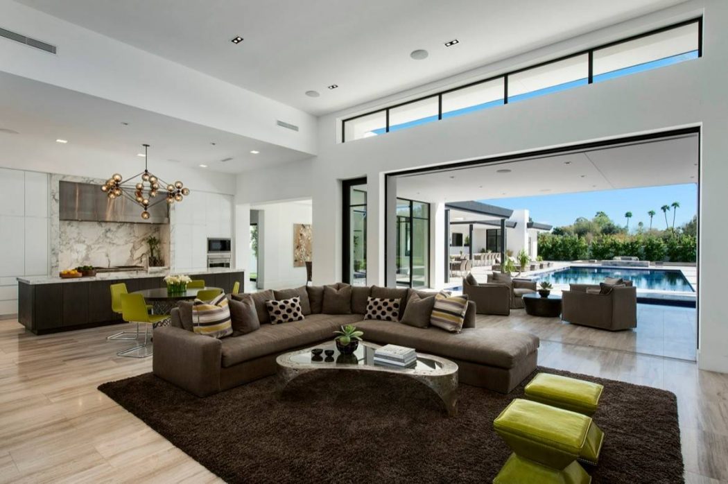 Sleek, modern living area with large windows, plush seating, and contemporary design.