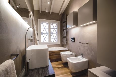 A modern bathroom with a freestanding bathtub, bidet, and large windows overlooking the interior.