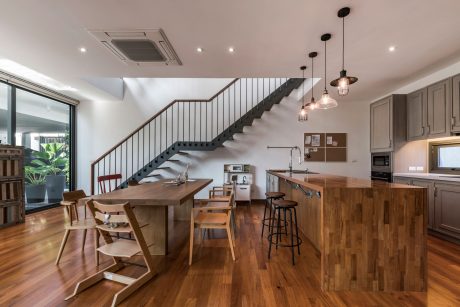 Modern open-concept kitchen and dining area with rustic wood accents and minimalist decor.