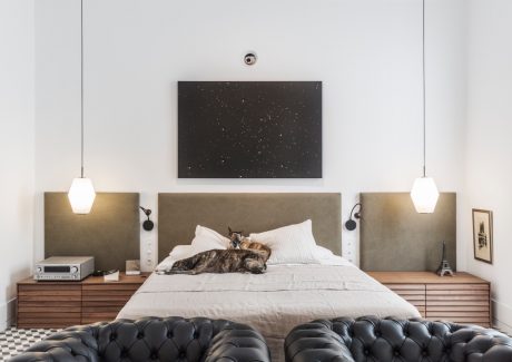 Spacious bedroom with elegant lighting, plush furniture, and modern design elements.