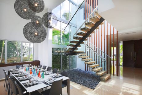 Sleek modern interior with glass walls, spiral staircase, and geometric lighting fixtures.