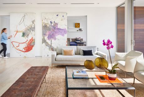 Contemporary living room with eclectic art, plush seating, and patterned furnishings.