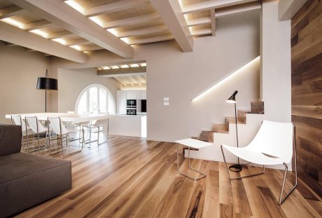 A modern, open-concept living space with wooden accents, arched windows, and a minimalist design.