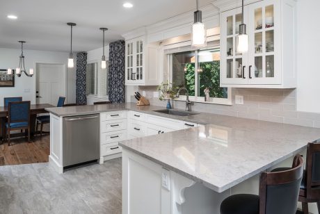 Sophisticated kitchen design with sleek white cabinets, marble countertops, and stylish pendant lights.