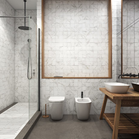 Minimalist bathroom with marble tile walls, wooden vanity, and sleek shower fixtures.