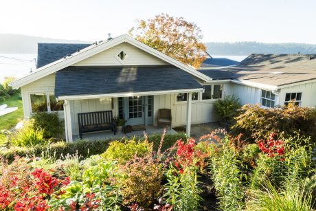 Cozy country cottage with a charming porch, surrounded by a vibrant garden.