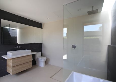 Modern bathroom with sleek vanity, glass shower enclosure, and stylish tiling.