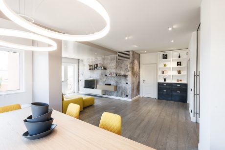 Spacious, modern living room with minimalist design, sleek built-in storage, and warm wood flooring.
