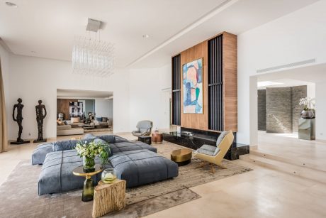 Spacious living room with modern, minimalist decor and custom wood paneling feature.
