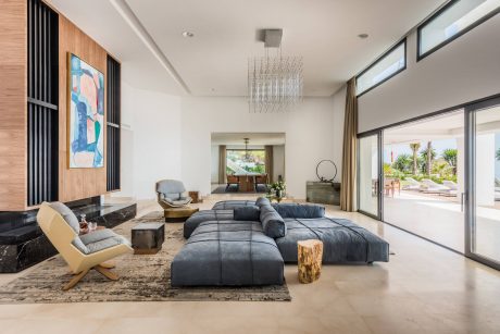 Expansive open-concept living area with sleek furniture, contemporary lighting, and outdoor views.