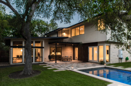 Striking modern home with clean lines, large windows, and an inviting pool area.