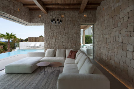 Rustic stone walls, wooden beams, and modern furnishings create a cozy, luxurious space.
