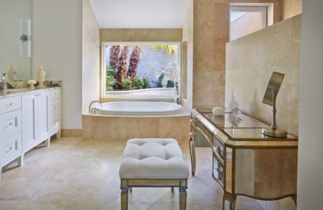Spacious bathroom with luxurious tub, vanity, and antique-style furniture.