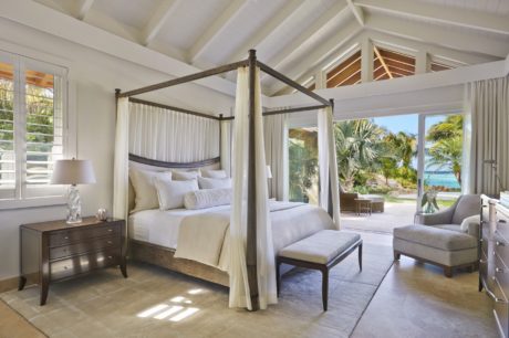 Luxurious bedroom with a vaulted ceiling, canopy bed, and panoramic ocean views.