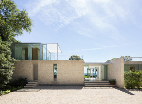 Striking modern residence with distinctive glass and brick facade, open-plan layout.
