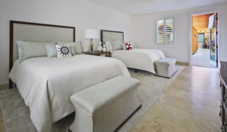 Spacious, well-designed bedroom with plush bedding, modern decor, and sliding glass doors.
