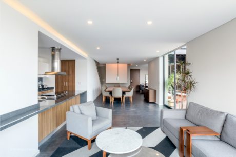 Spacious, open-concept living area with sleek, modern kitchen and dining furniture.