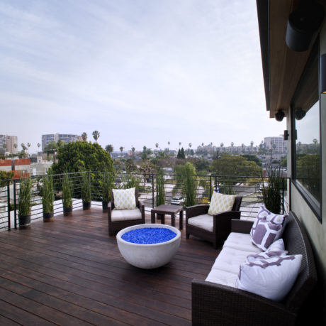 Spacious outdoor deck with comfortable seating, decorative planters, and a small water feature.