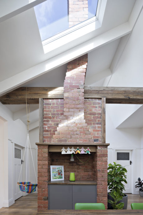 Spacious interior with exposed brick wall, wooden beams, and contemporary furnishings.