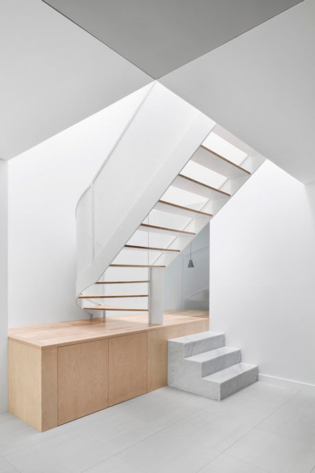 Minimalist interior with geometric wooden and concrete stairs, storage unit.