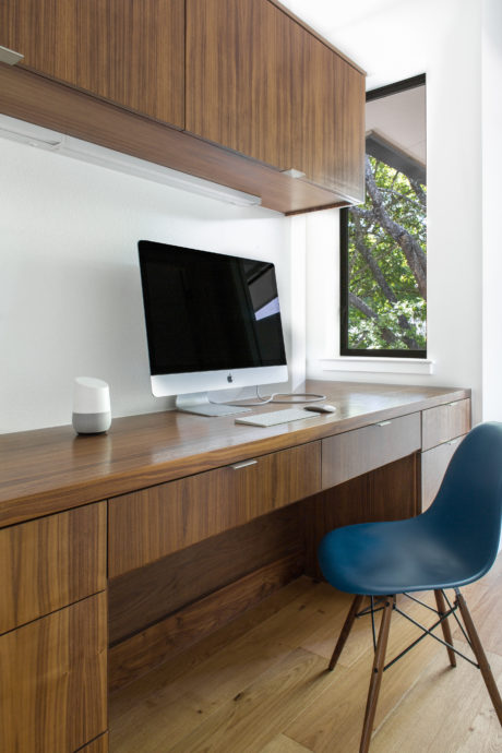 Well-designed home office with modern wood cabinetry, desktop, and ergonomic chair.