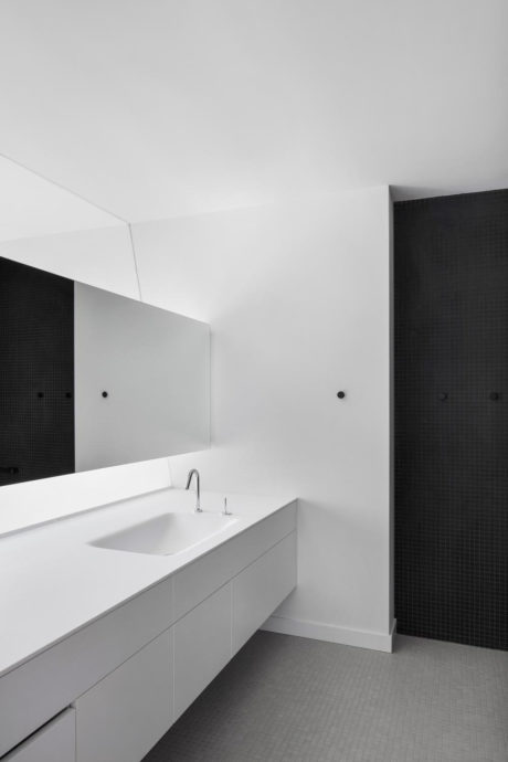 A minimalist bathroom design featuring clean lines, monochrome tones, and a sleek vanity.