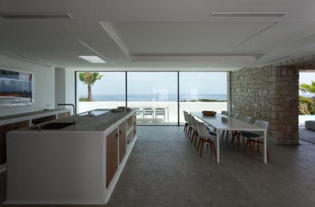 Spacious open-plan kitchen and dining area with floor-to-ceiling windows offering stunning ocean views.