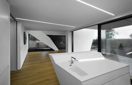 Modern and minimalist interior with sleek lines, recessed lighting, and a large bathtub.