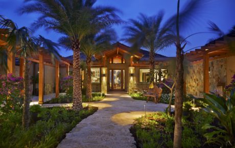 Luxurious desert retreat with wooden architecture and tropical landscaping.