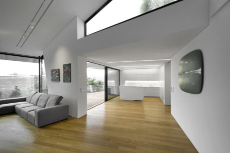 Spacious open-concept living room with floor-to-ceiling windows, modern furniture, and minimalist design.