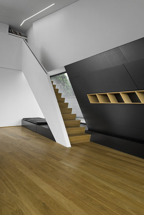 Minimalist staircase with sleek black and wood finishes, creating a modern, artistic space.