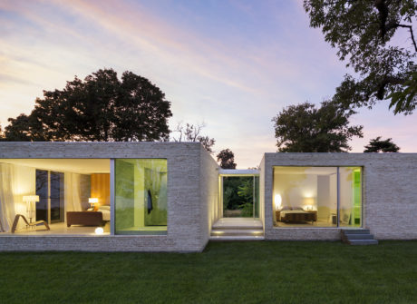 Modern residential home with clean lines, large windows, and a green outdoor area.