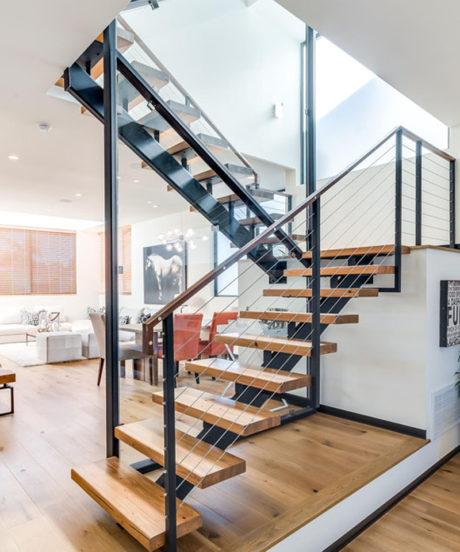 Striking modern staircase with contrasting wood and metal elements; open, airy design.