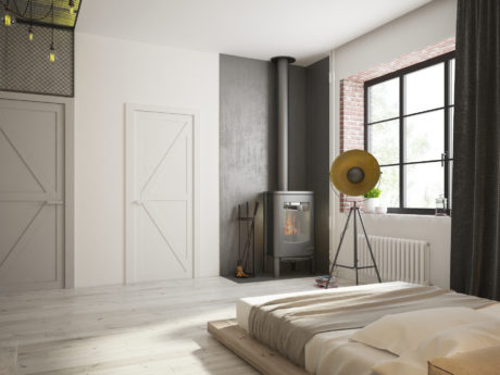 Minimalist bedroom design featuring wood-paneled walls, fireplace, and decorative lamp.