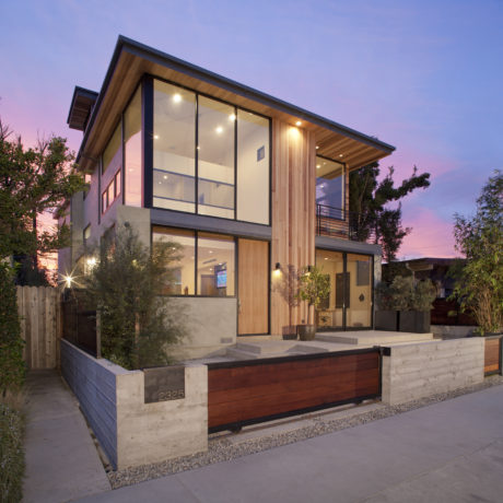 Modern two-story home with mixed materials, large windows, and a covered porch.