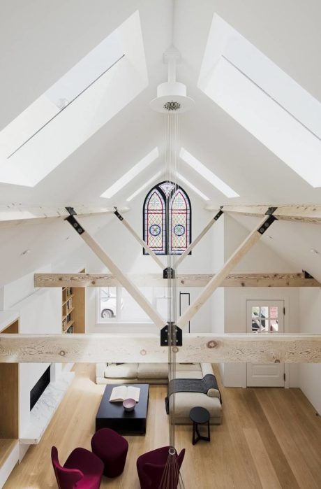 Bright loft space with skylights, decorative stained glass window, and minimalist decor