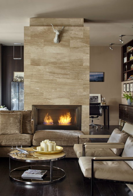 Cozy living room with a stone fireplace, plush furniture, and layered decor.