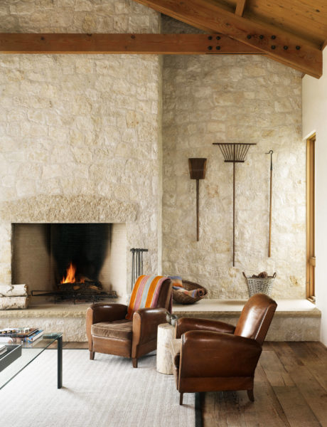 Rustic living room with stone fireplace and wooden beams.