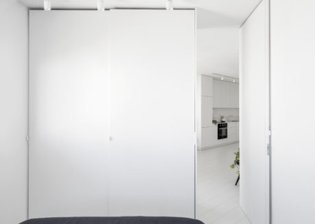 Minimalist interior with plain white walls, concrete floor, and recessed lighting.